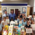 Rob and Ryan at Pottenger Elementary School Library with children staff and books