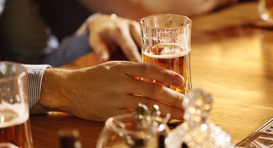 man drinking beer at bar